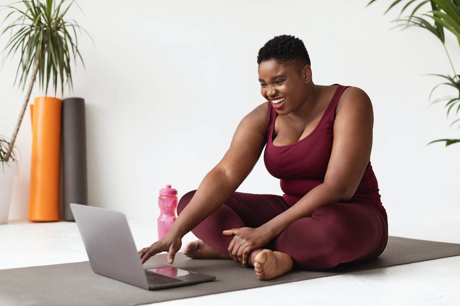 Positive overweight african american woman enjoying remote workout